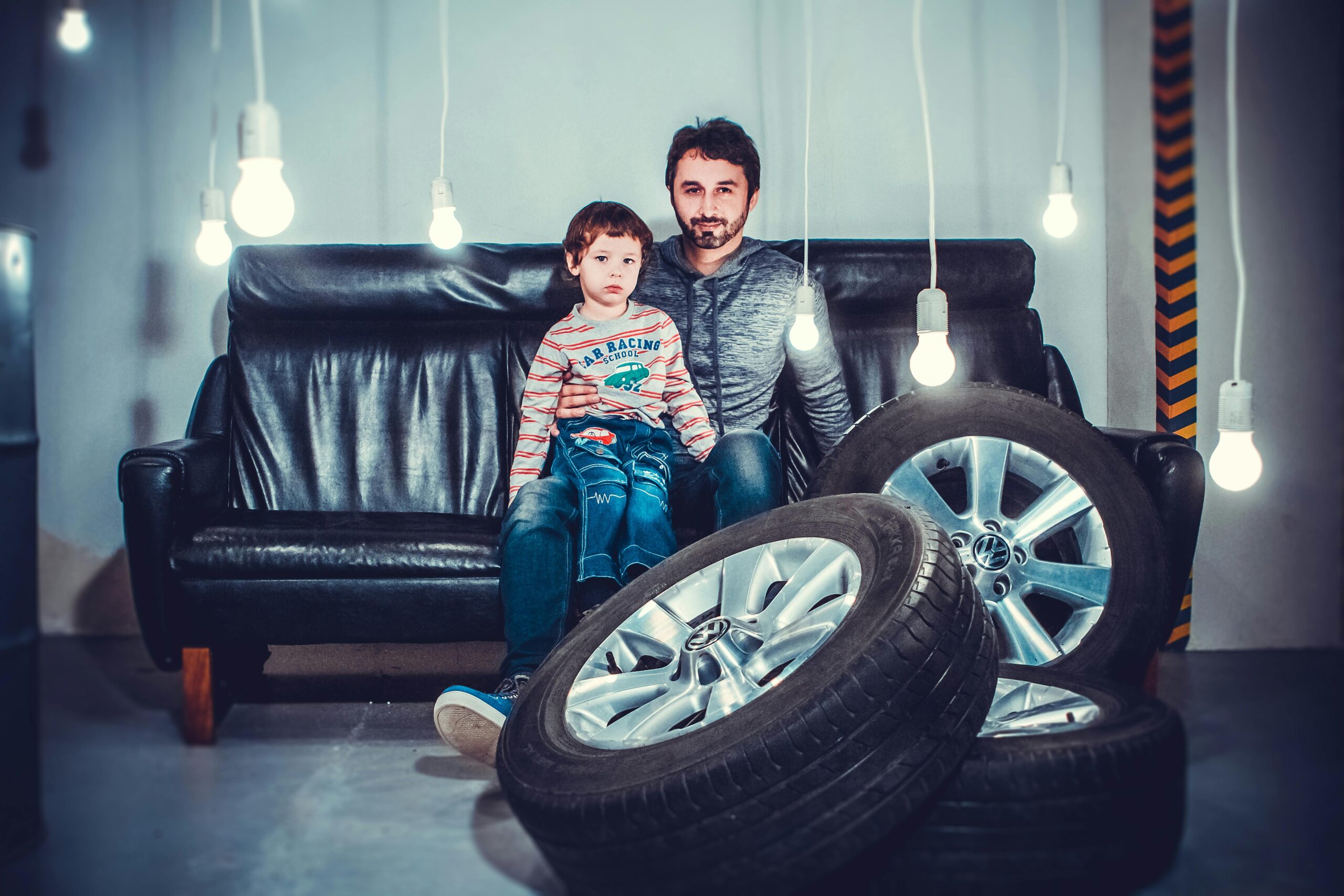 Father and son on a couch with tires in front of them